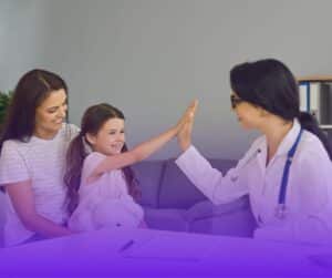 Healthcare professional high-fiving young girl