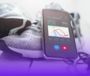 A pair of trainers and a phone with a running tracker app