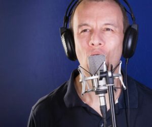 actor with headphones using a mic